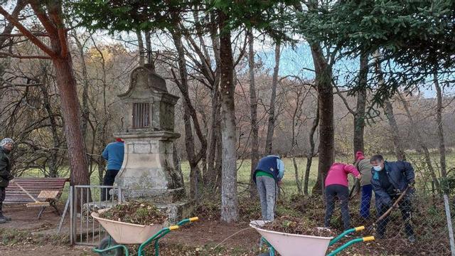 Seis vecinos de Santa Colomba de Sanabria adecentan el entorno del crucero de la Vera Cruz. | A. Saavedra
