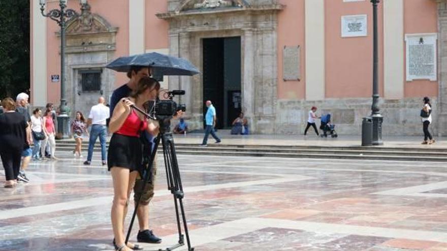 Raquel Agea y Héctor Tarancón ruedan imágenes para su corto en la plaza de la Virgen de València.