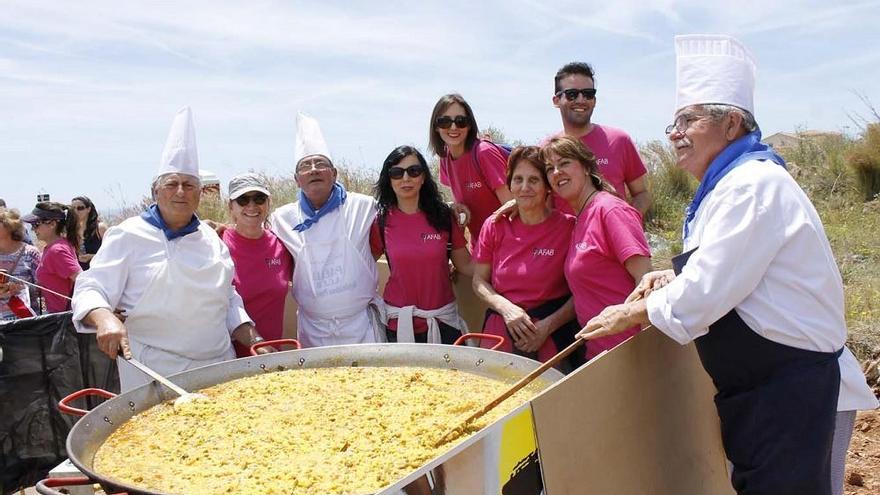 Un grupo de familiares y simpatizantes de la asociación, junto a los artífices de la paella.