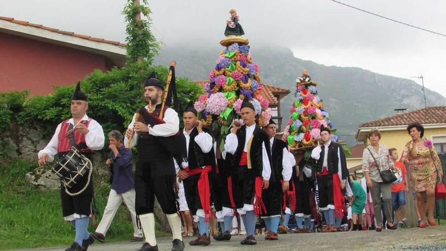 El gaitero Santi Galguera y el gaitero Paco Cue, con los ramos, durante la procesión.
