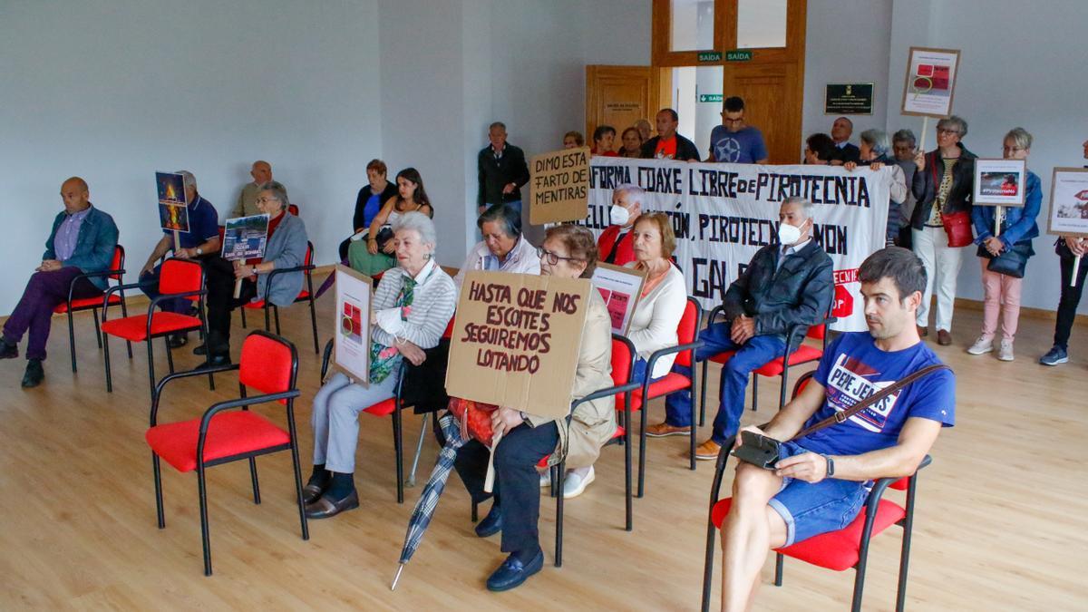 Los vecinos con sus pancartas, durante el pleno.