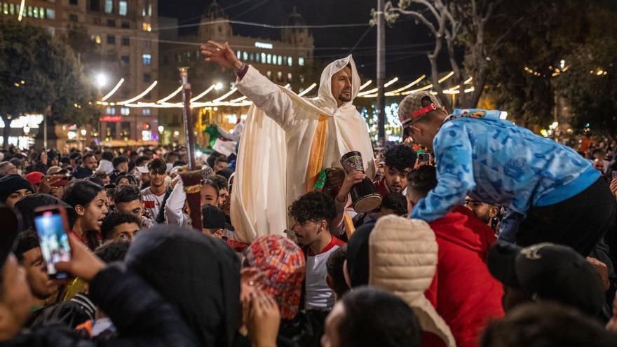 Varios seguidores marroquíes, en la plaza de Catalunya celebran la clasificación de su selección de fútbol.