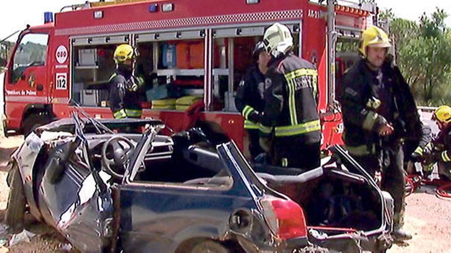 Varios bomberos, junto al vehículo siniestrado ayer a mediodía en la autopista de Inca.