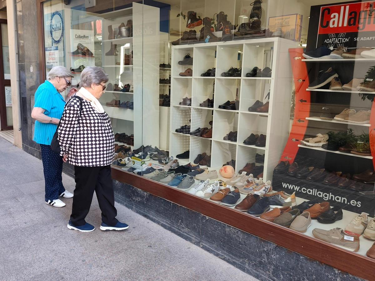 Dos mujeres observan una zapatería en Lucena.