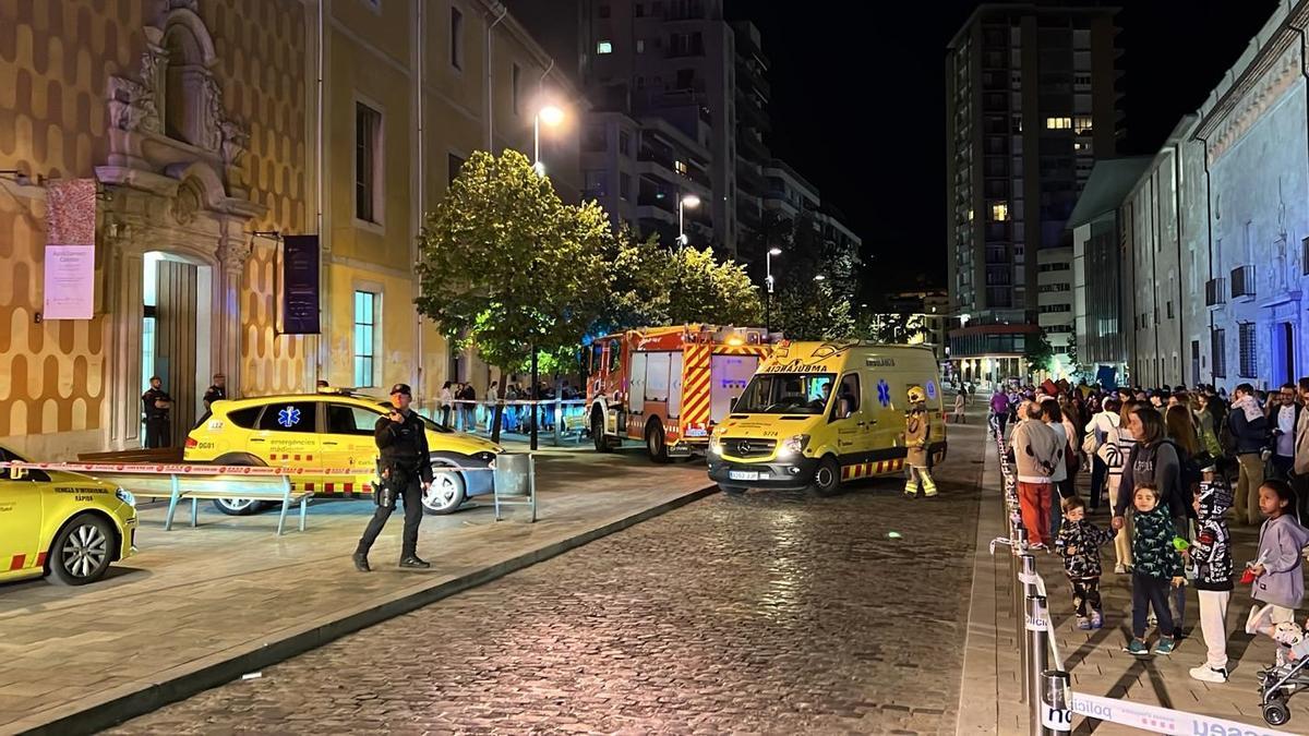 Un grup de persones observa les tasques del SEM i dels Bombers després d'una explosió a la Casa de Cultura de Girona