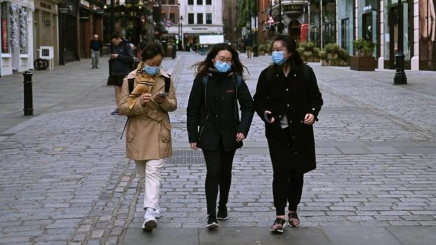 Personas con máscaras caminan en Londres.