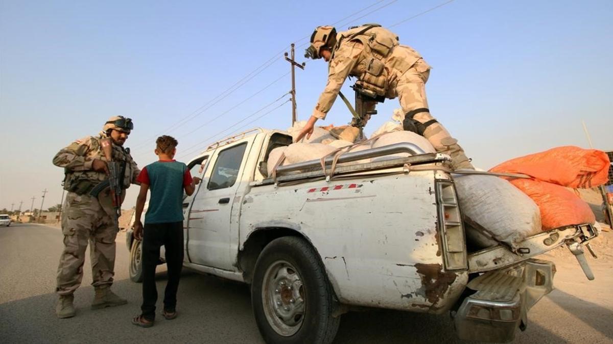 Soldados iraquís inspeccionan vehículos en el norte de Irak.