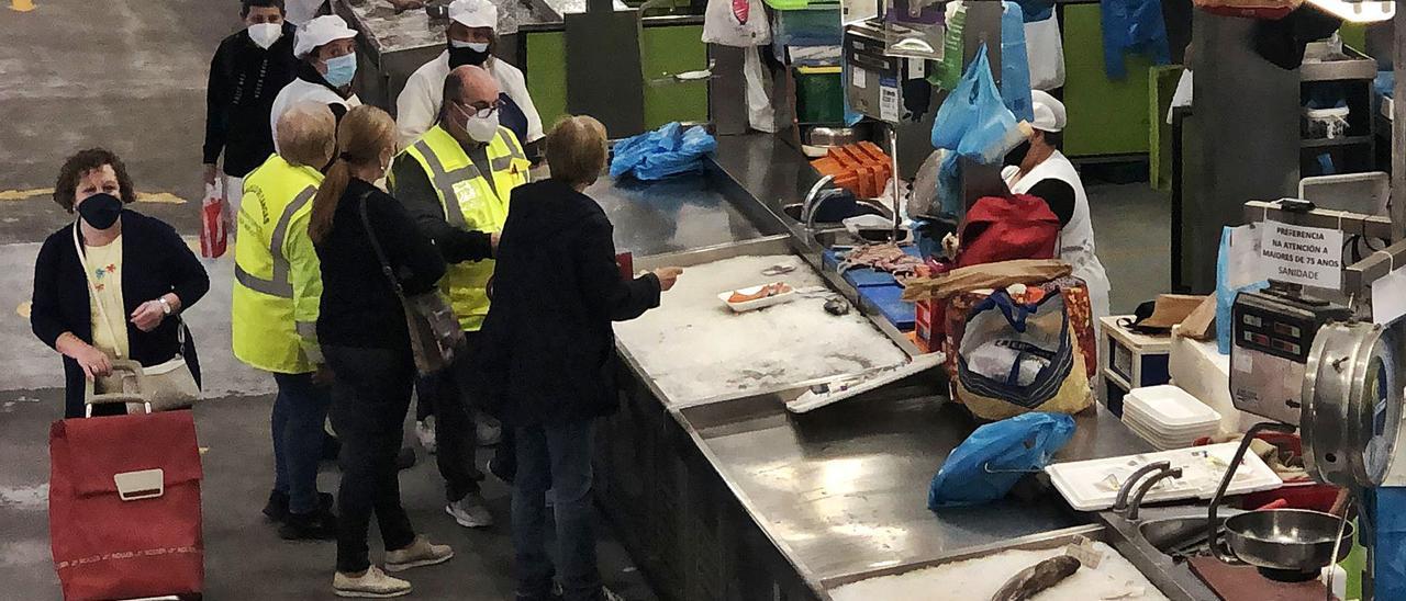 Conserjes municipales, supervisando la actividad en la plaza de abastos