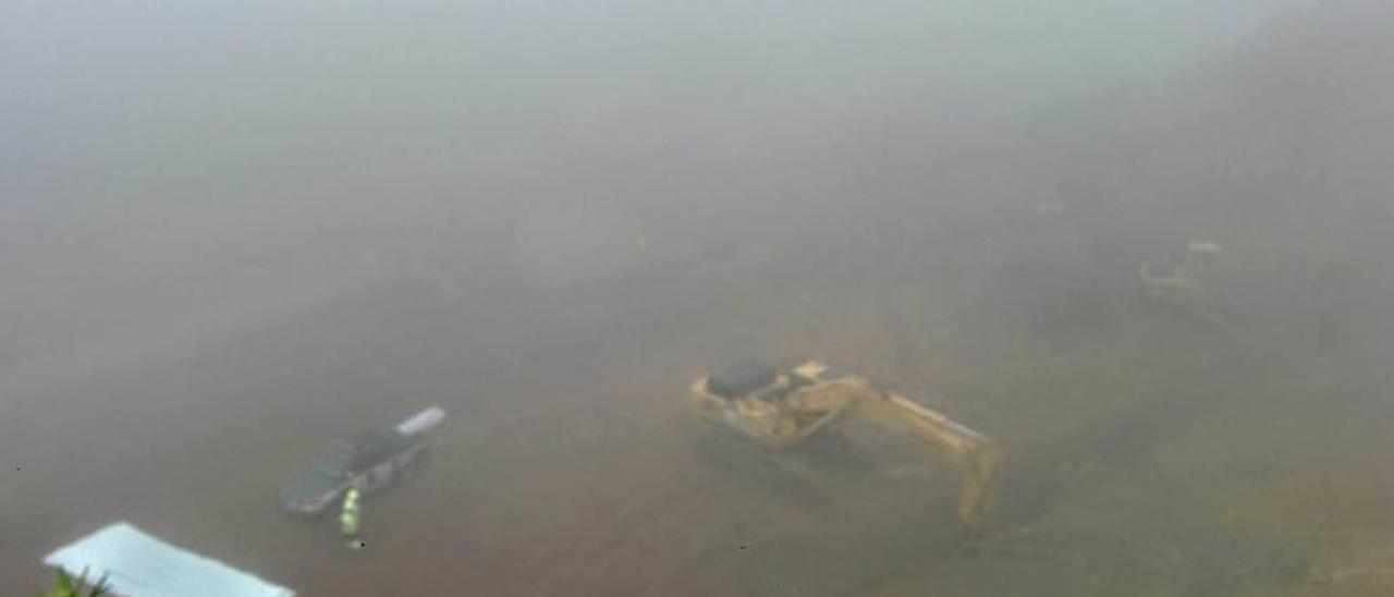 Máquinas trabajando ayer entre la niebla en la zona del argayo.