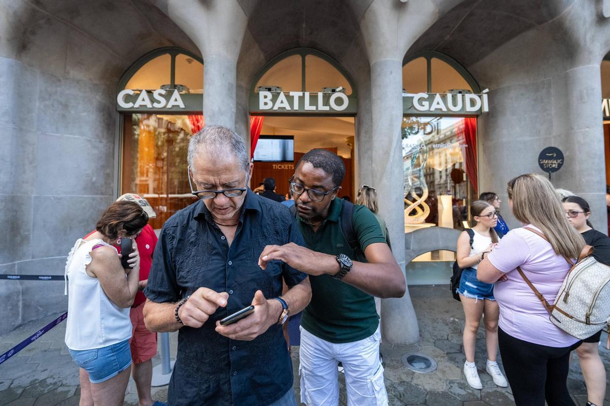 Turistas, a la entrada de la Casa Batlló, este lunes, consultando su entrada antes de acceder al 43 de paseo de Gràcia