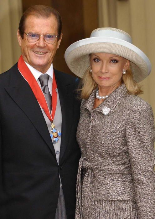 Roger Moore y su esposa Kristina Tholstrup en el Palacio de Buckingham (2003).