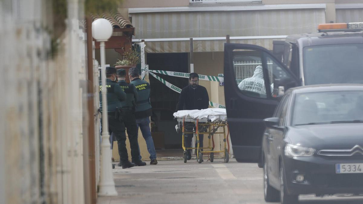 Levantamiento del cuerpo sin vida de la mujer asesinada.