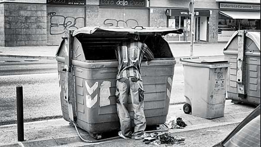 Un hombre busca comida en un contenedor de basura. // &quot;The New York Times&quot;