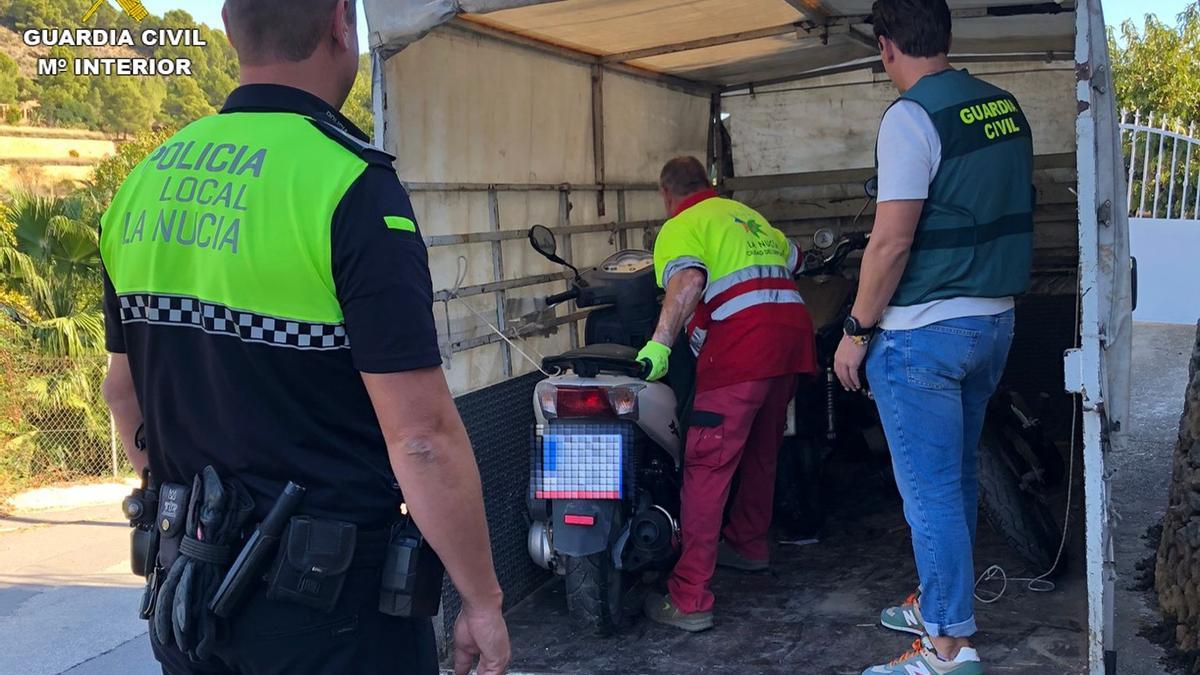 Agentes de la Guardia Civil y de la Policía Local de La Nucía junto a una moto recuperada.