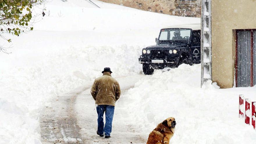 Un hombre camina en la localidad leonesa de Casares de Arbás, tras las intensas nevadas caídas en los últimos días.