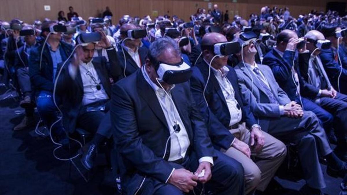 Asistentes a la presentación del nuevo 'smartphone' Galaxy S7 de la firma Samsung con los gafas Gear VR para la visión en 3D.