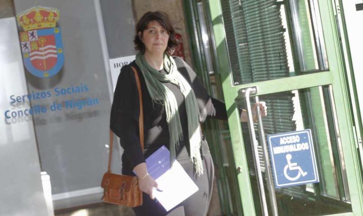 María Santos, autora del proyecto, junto a un cartel incomprensible y otro peyorativo, en el Concello. // J. Lores