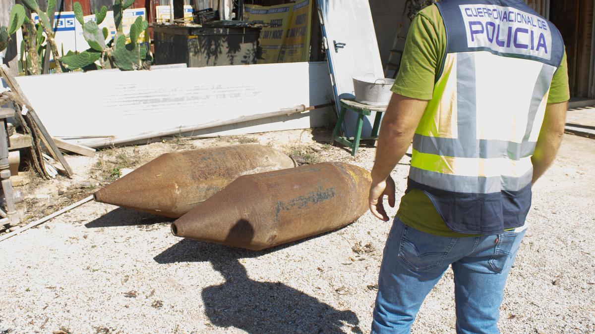 Un agente mira dos de las piezas recuperadas en la finca del nonagenario en Torre Pacheco.