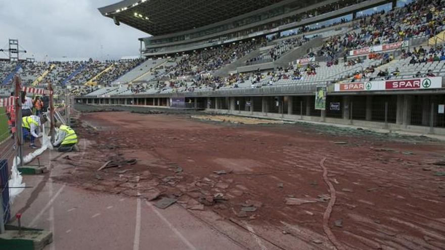 El de ayer fue el primer partido con las vallas muy cerca del césped y escombros donde antes estaban las pistas de atletismo. Cuatro operarios del Cabildo recogen los balones que caen en la &#039;zona cero&#039;.