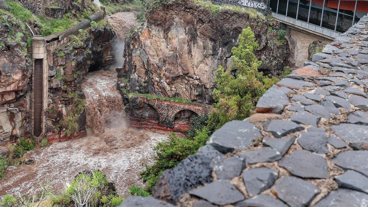 Una mujer observa la crecida del Barranco Santos en Santa Cruz de Tenerife.