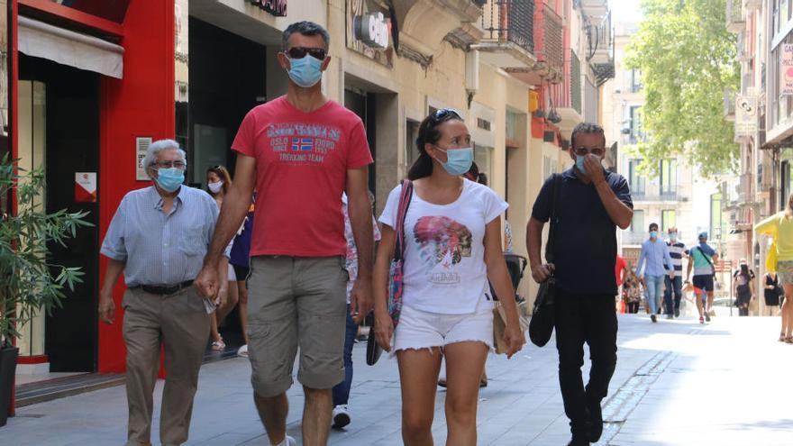 Un grup de persones davant de les botigues de Figueres