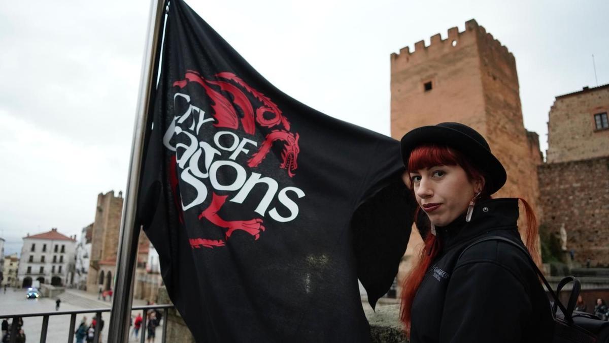 Una fan de Juegos de tronos junto a la bandera Targaryen en el Ayuntamiento de Cáceres.