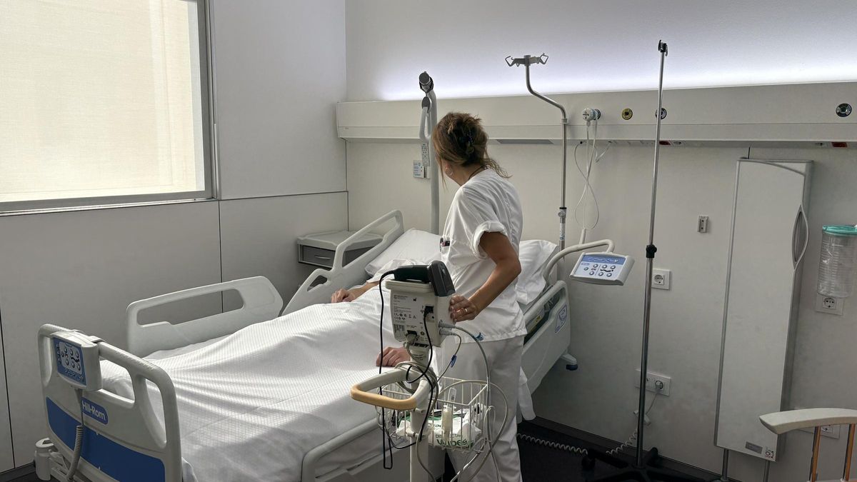 Una sanitària atén un pacient hospitalitzat a Olot.