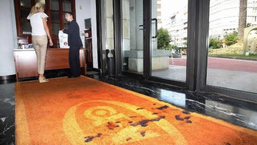 Daños que causó el cóctel molotov en la alfombra y la puerta principal del Club Financiero. / r. grobas