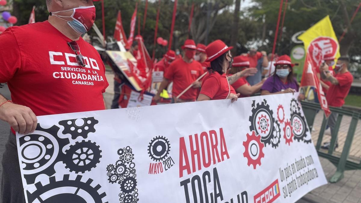 Manifestantes sostienen una pancarta con motivo del Primero de Mayo