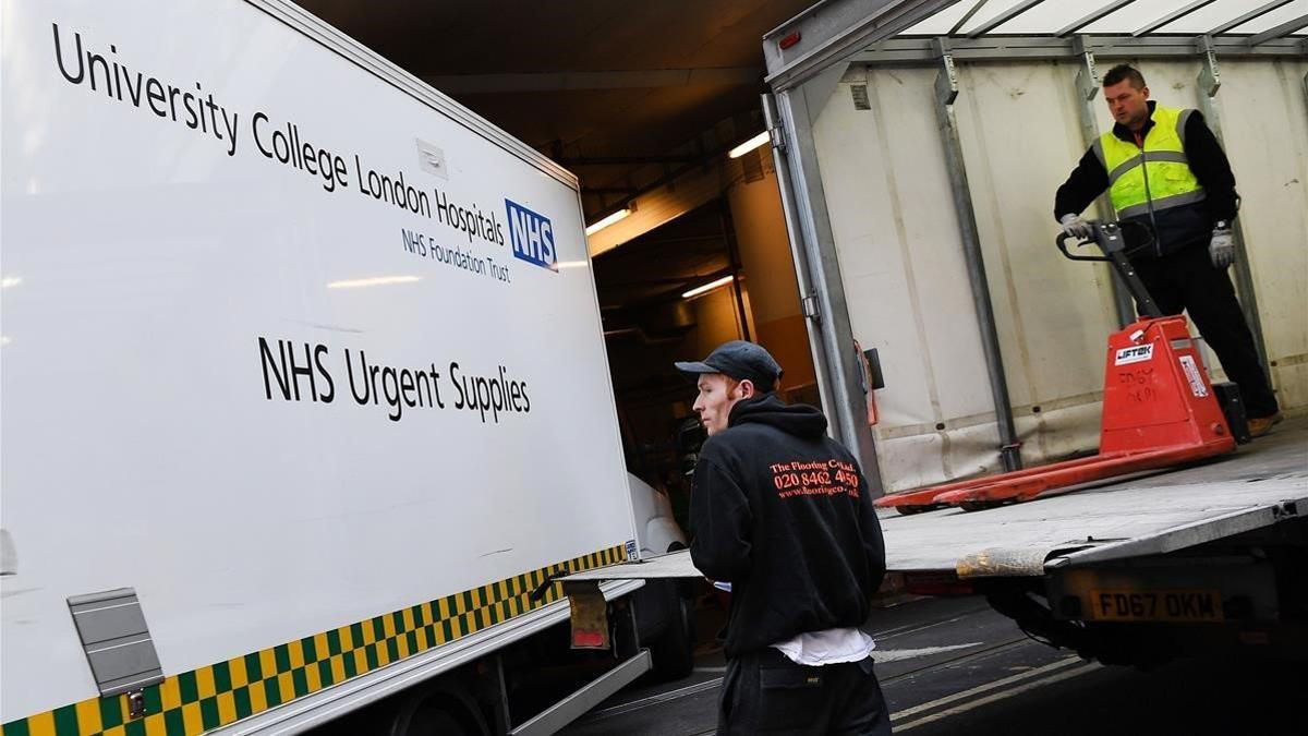 Unos operarios descargan suministros del servicio público de sanidad del país (NHS) en un hospital de Londres, el 25 de marzo del 2020
