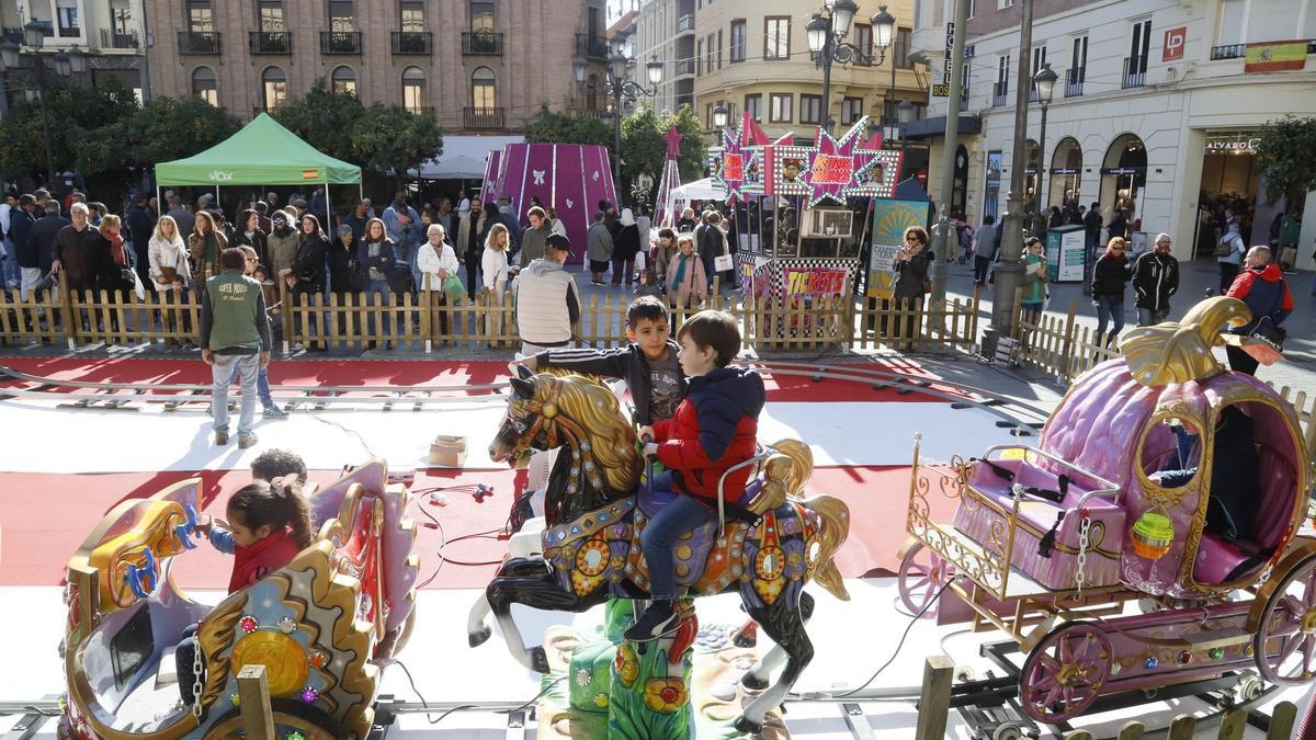 Ambiente navideño en la plaza de Las Tendillas con las atracciones infantiles.