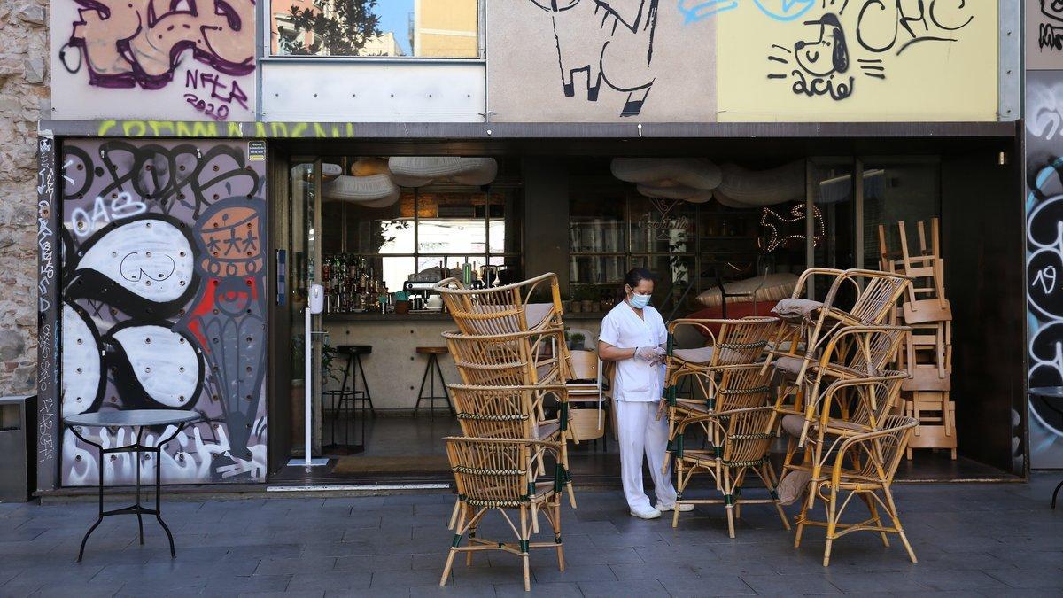 Sillas de una terraza de un bar de Barcelona amontonadas en la puerta, el 14 de octubre del 2020