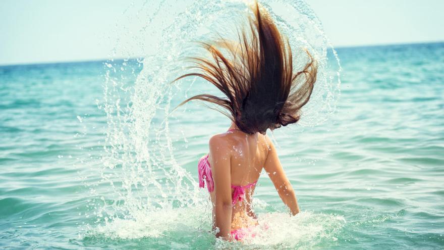 Joven dándose un baño en la playa