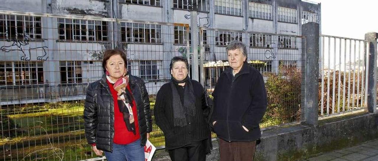 Las extrabajadoras Manuela, Esther y Nieves ante la fábrica abandonada de GEA en Cabral. // J. Lores