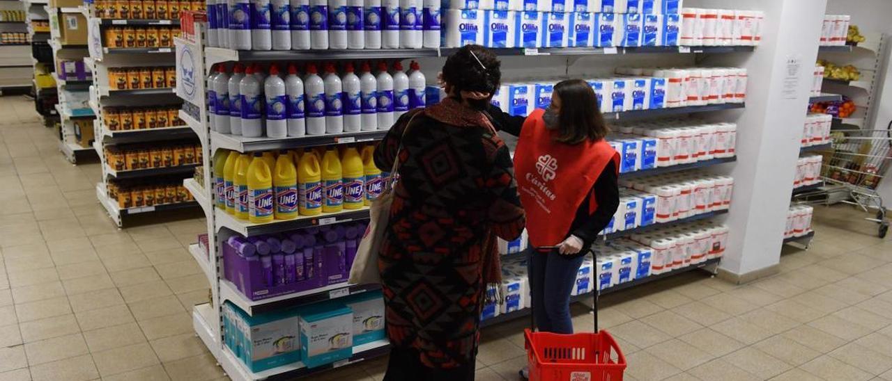 Una mujer junto a una voluntaria en el economato de Cáritas, en A Coruña.