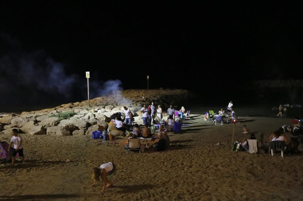 Noche de hogueras, baños, en las playas de la Vega Baja. En las imágenes grupos de amigos y familias en la playa del Cura de Torrevieja