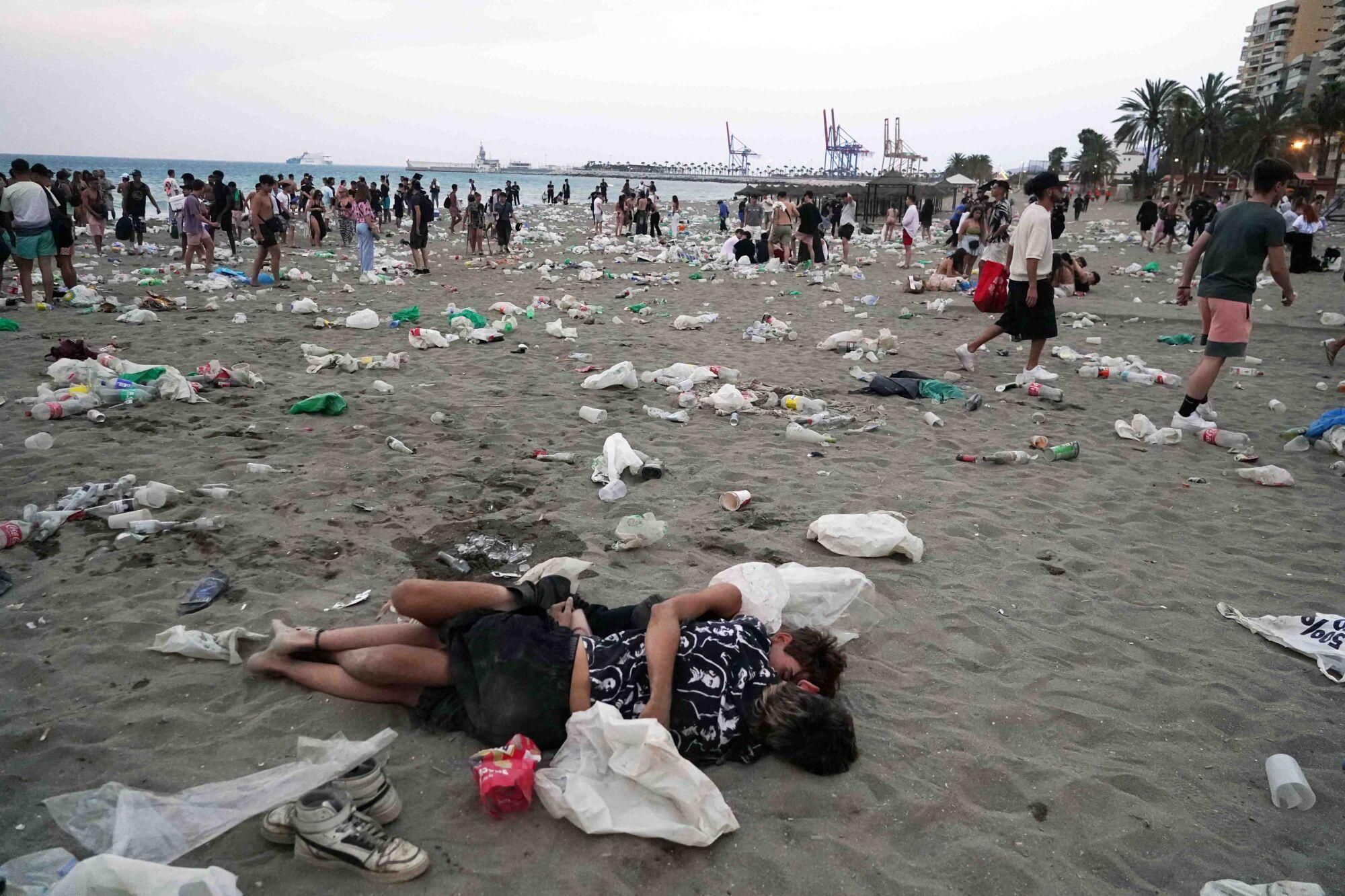 Varios operarios de la empresa de limpieza de Limasam, recogen los residuos de la playa de La Malagueta, tras la Noche de San Juan en Málaga 2025