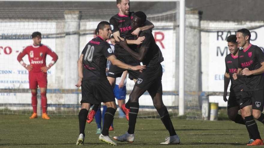 Robert salta para abrazarse a Saha en la celebración del único gol del partido, con Medori de espaldas.