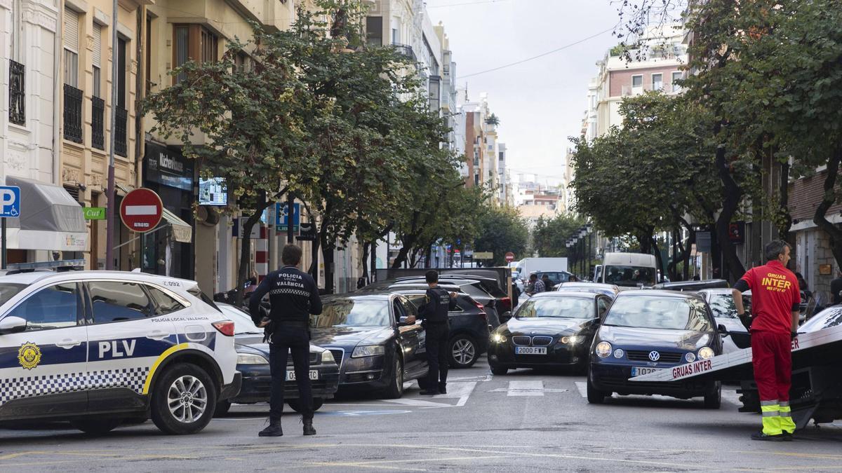La grúa municipal se lleva una serie de vehículos en una calle de València.