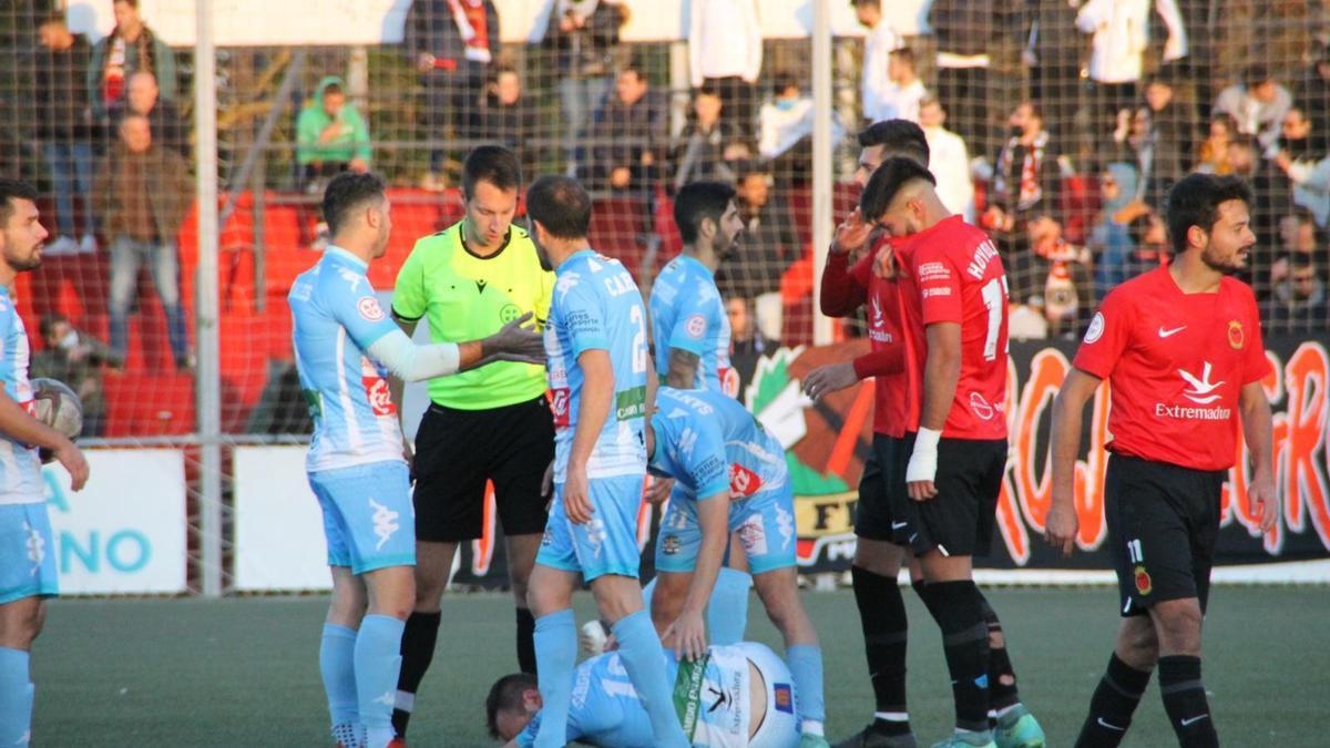 Los jugadores del Coria hablan con el árbitro tras una falta.