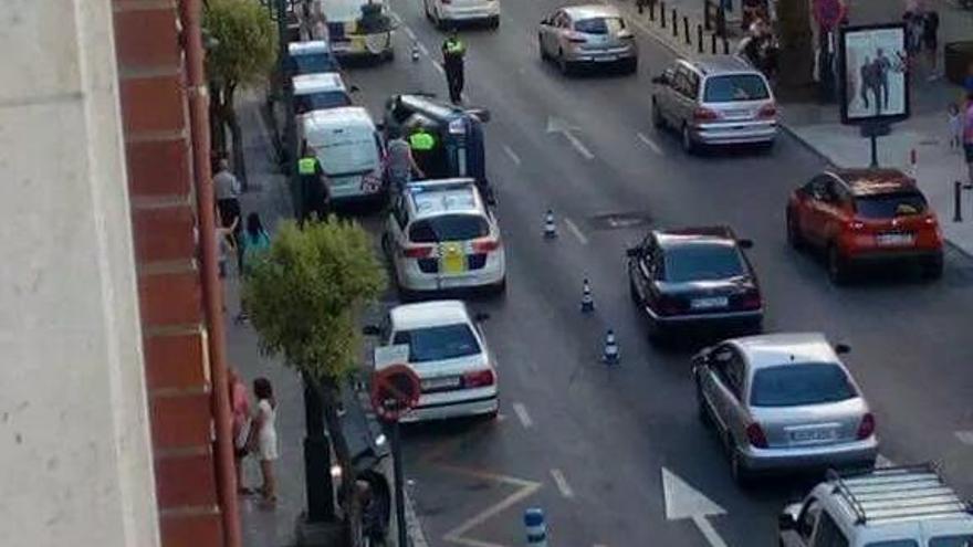 Imagen general de la calle con el coche volcado