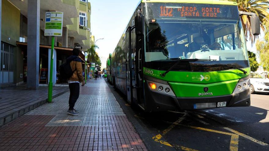 Un joven espera la guagua en una parada.