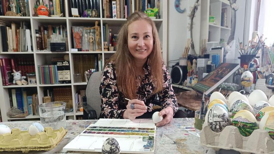Mariana Fano decora uno de sus güevos pintos en el taller de su casa de Pola de Siero.