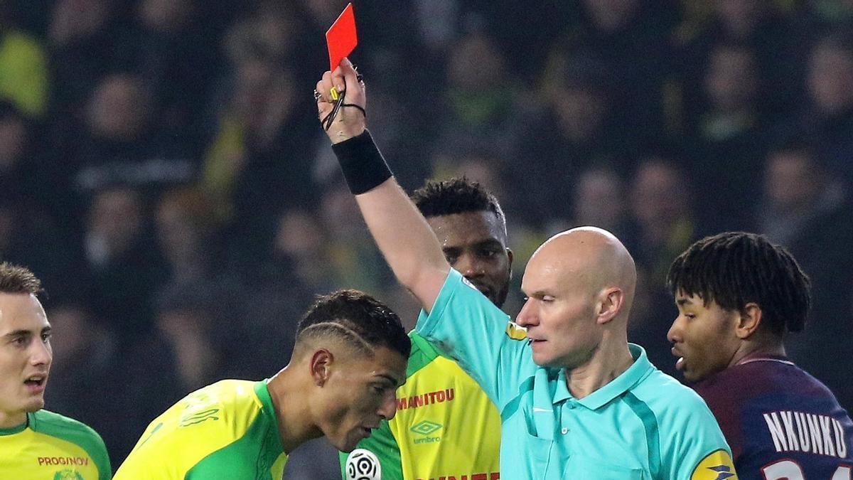 Tony Chapron muestra una roja durante un partido de la Ligue 1.