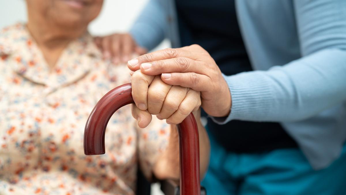 Una persona atiende a una señora mayor.