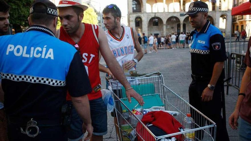 Agentes de la Policía Municipal confiscan un carro de supermercado durante las pasadas fiestas.