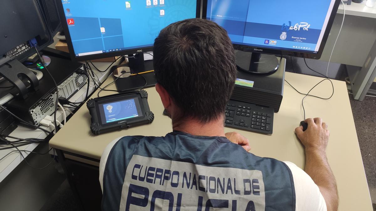 Un Policía del Grupo de Delitos Tecnológicos ante dos ordenadores.