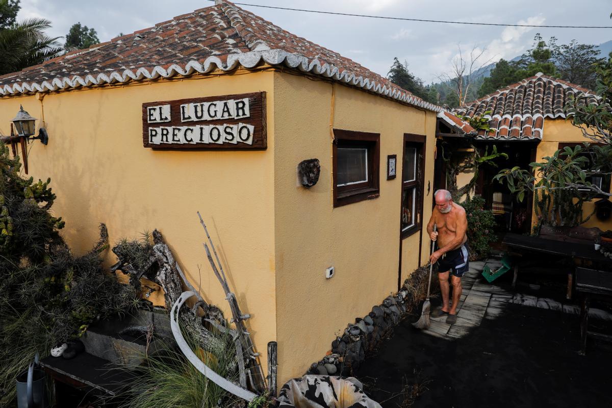 Gert Waegerle limpia la ceniza que cubre la entrada de su casa en Tacande de Arriba. El hombre, de 75 años, fue evacuado de su hogar ante la amenaza del volcán, pero ha podido regresar.