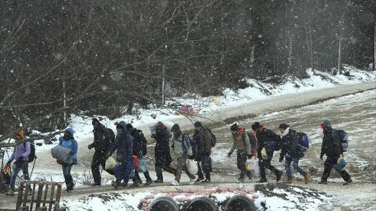 Varios refugiados se dirigen a un campamento en Miratovac (Serbia).