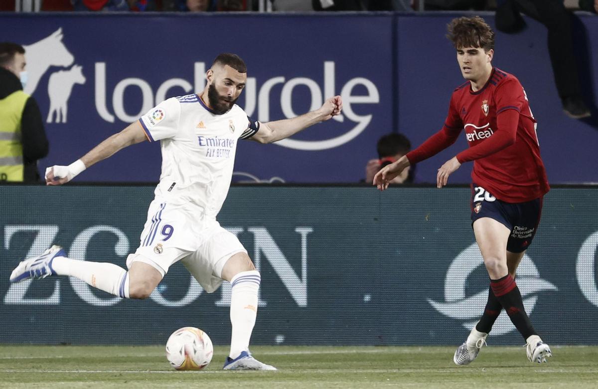 PAMPLONA, 20/04/2022.- El delantero francés del Real Madrid, Karim Benzema (i), se dispone a golpear el balón ante el delantero de Osasuna, Barbero, durante el encuentro correspondiente a la jornada 33 de primera división que disputan hoy miércoles en el estadio del Sadar, en Pamplona. EFE / Jesús Diges.